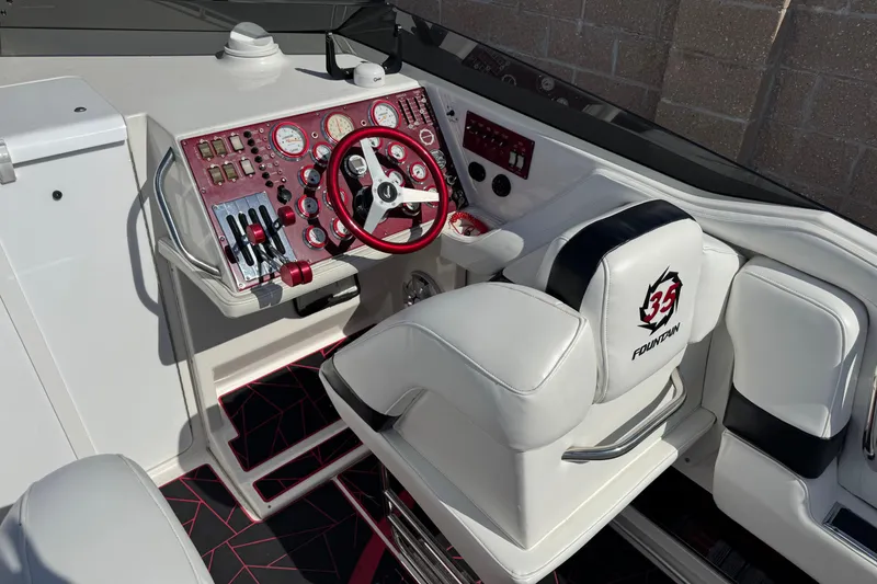 Slide: The Image of 2004 Fountain 35 Executioner boat cockpit with red and white controls and steering wheel. - 7