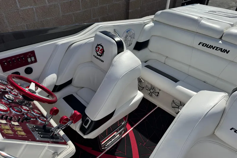 Slide: The Image of Interior of a 2004 Fountain 35 Executioner boat with white seating and red controls. - 9
