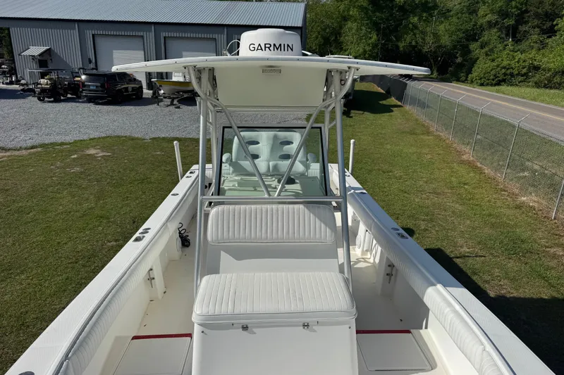 Slide: The Image of 2000 Regulator 26 Forward Seating boat with Garmin equipment, parked on grass near a road. - 6