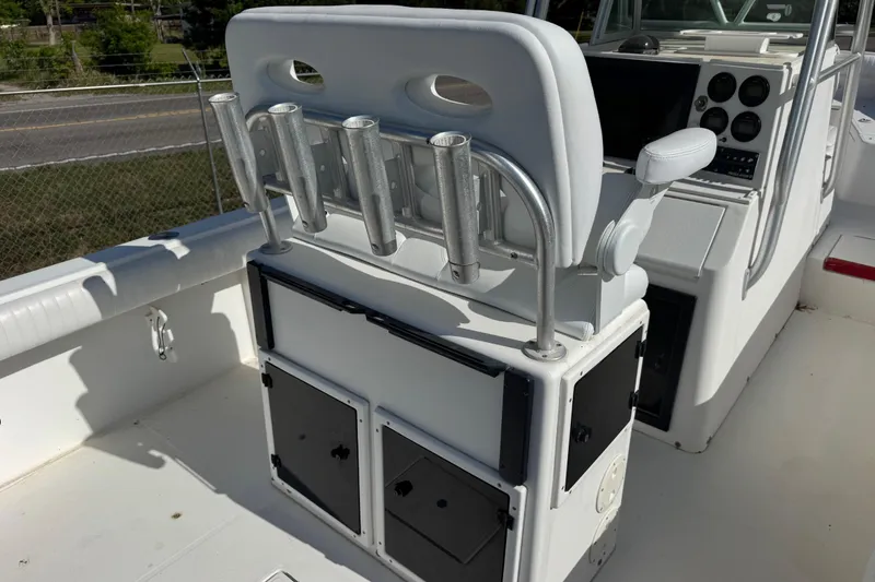 Slide: The Image of 2000 Regulator 26 Forward Seating boat interior with rod holders and control panel. - 8