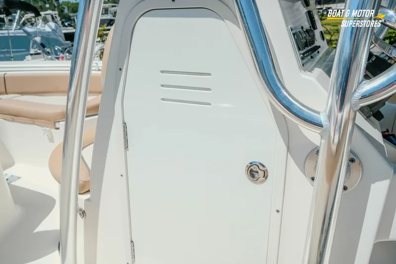 Slide: The Image of 2020 Key West 219 FS boat console with stainless steel railings and beige seating. - 13