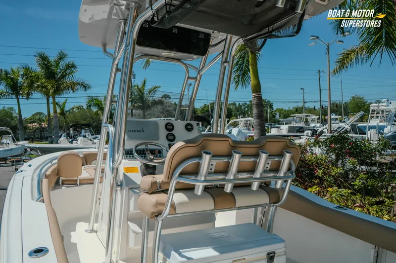Slide: The Image of 2020 Key West 219 FS boat interior with helm, seating, and palm trees in the background. - 15