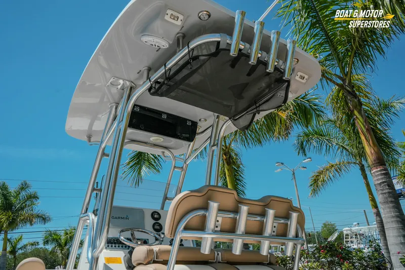 Slide: The Image of 2020 Key West 219 FS boat with T-top and rod holders, surrounded by palm trees. - 6