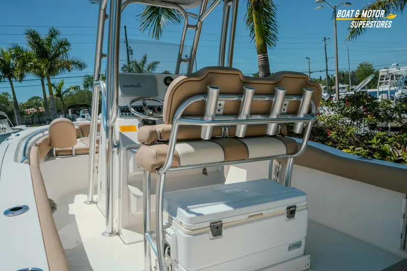 Slide: The Image of 2020 Key West 219 FS boat interior with seating and cooler, surrounded by palm trees. - 7