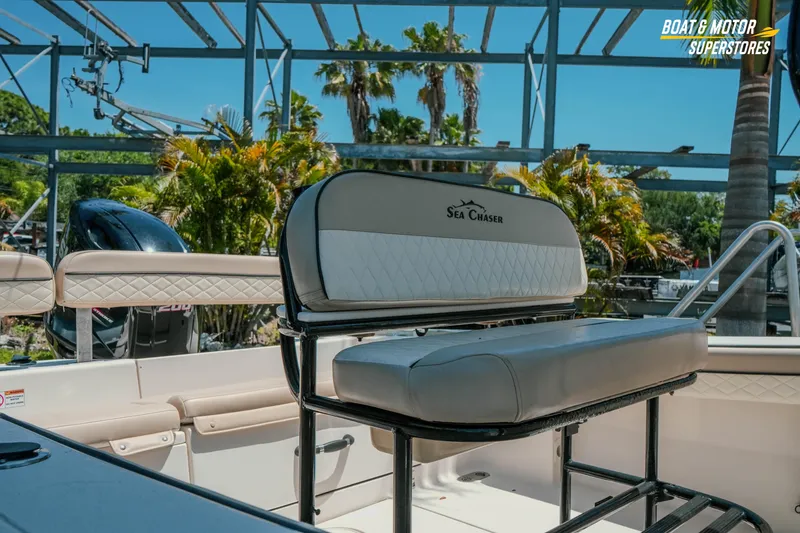 Slide: The Image of 2020 Sea Chaser 22 HFC boat interior with seating and motor, surrounded by tropical greenery. - 4