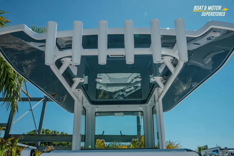 Slide: The Image of 2026 Blackfin 242 HB boat with rod holders and sleek design under clear blue sky. - 12