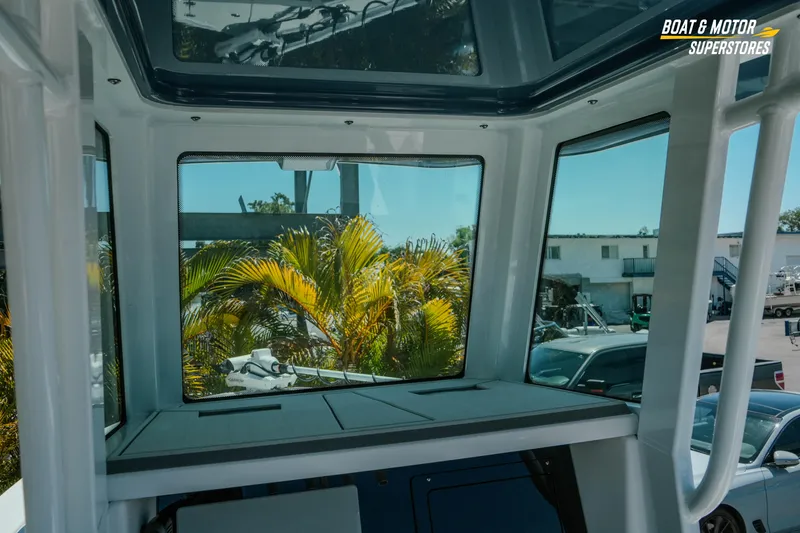 Slide: The Image of Interior view of 2026 Blackfin 242 HB boat with large windows and outdoor scenery. - 16