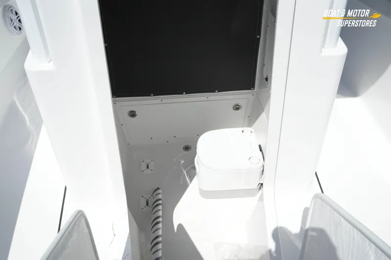 Slide: The Image of Interior of 2026 Blackfin 242 HB boat featuring a compact marine toilet. - 25
