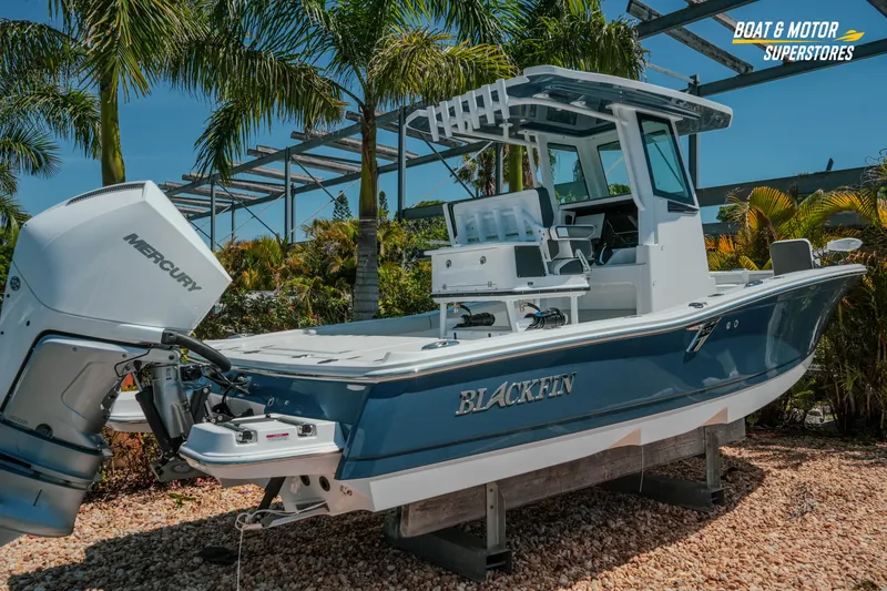 Slide: The Image of 2026 Blackfin 242 HB boat with Mercury engine, displayed outdoors under palm trees. - 3