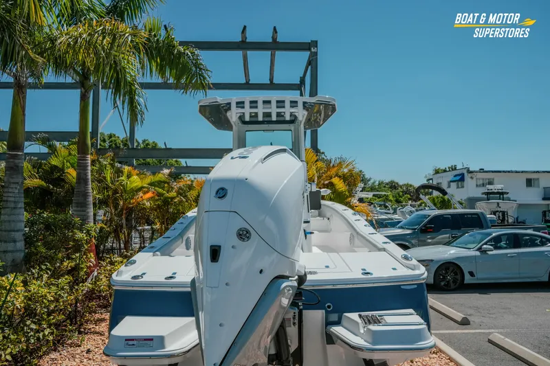 Slide: The Image of 2026 Blackfin 242 HB boat displayed outdoors at a dealership with palm trees. - 5