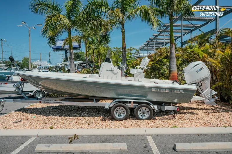 The Image of 2026 Skeeter SX221 boat on trailer, parked outdoors with palm trees in background. - 1