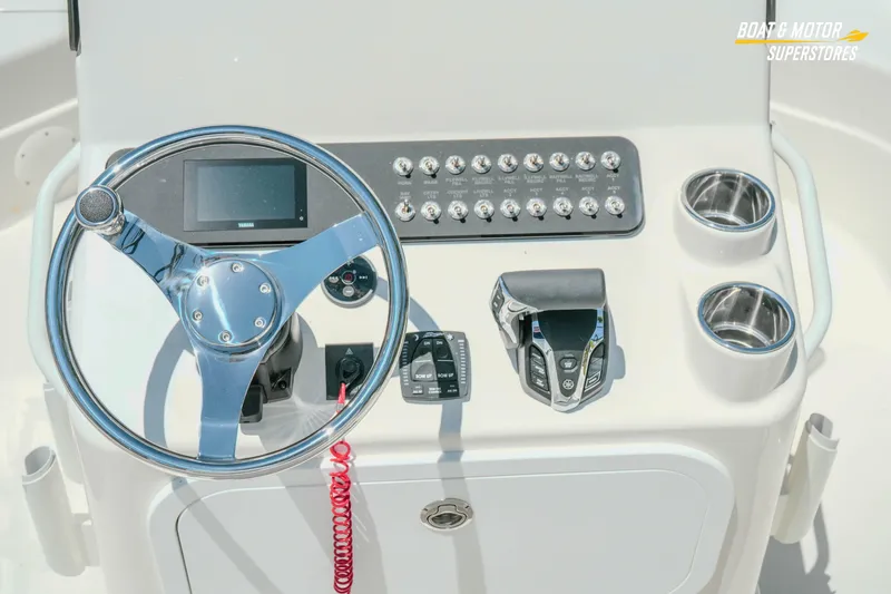 Slide: The Image of 2026 Skeeter SX221 boat console with steering wheel, controls, and cup holders. - 14