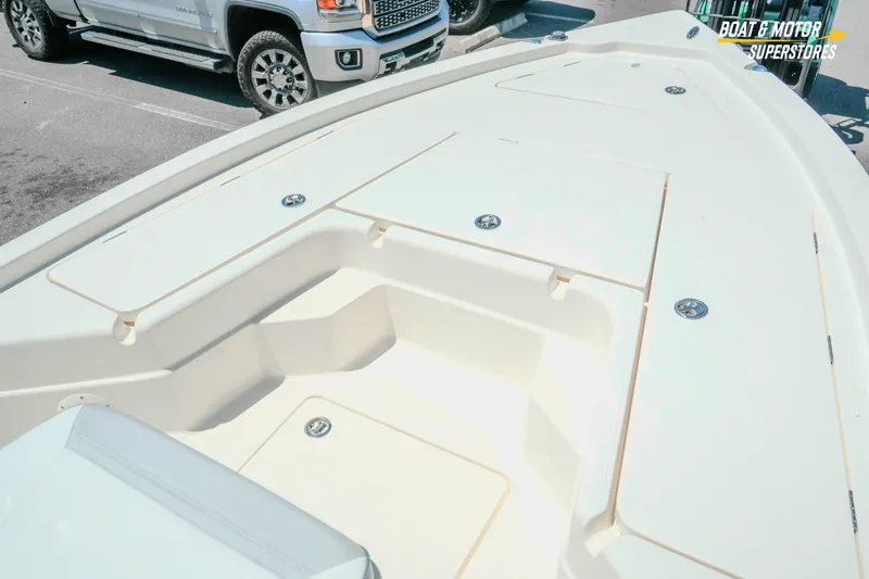 Slide: The Image of 2026 Skeeter SX221 boat deck with storage compartments in a parking lot. - 17