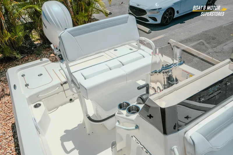 Slide: The Image of 2026 Skeeter SX221 boat interior with Yamaha engine, parked near a white car. - 24