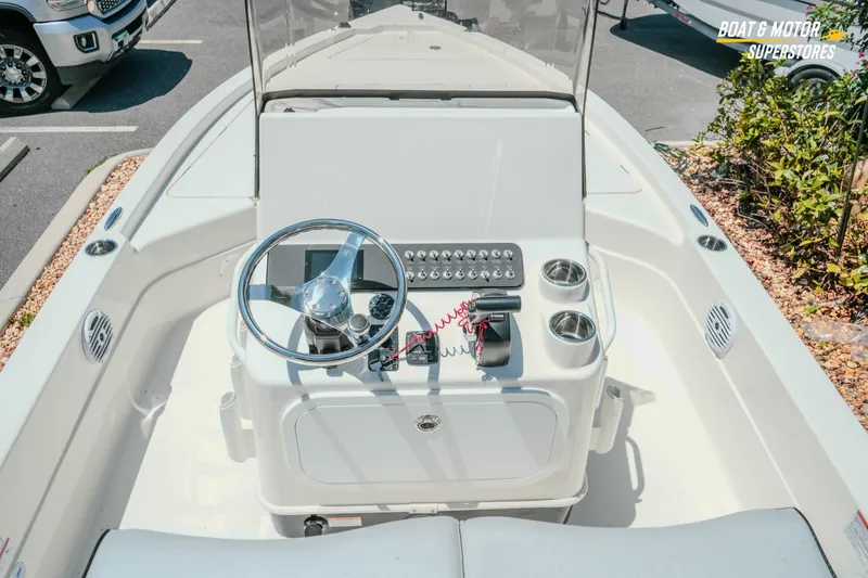 Slide: The Image of 2026 Skeeter SX221 boat console with steering wheel and controls in a parking lot. - 13