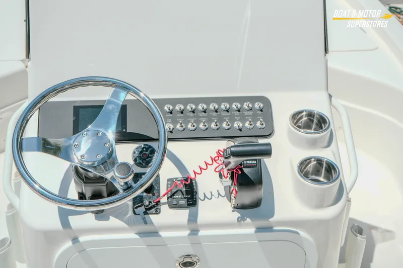 Slide: The Image of 2026 Skeeter SX221 boat console with steering wheel, controls, and cup holders. - 14