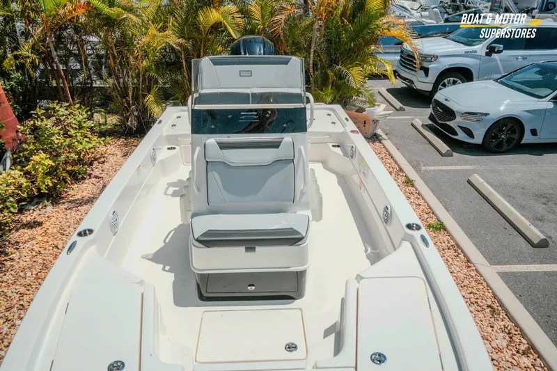 Slide: The Image of 2026 Skeeter SX221 boat in parking lot, surrounded by palm trees and vehicles. - 21