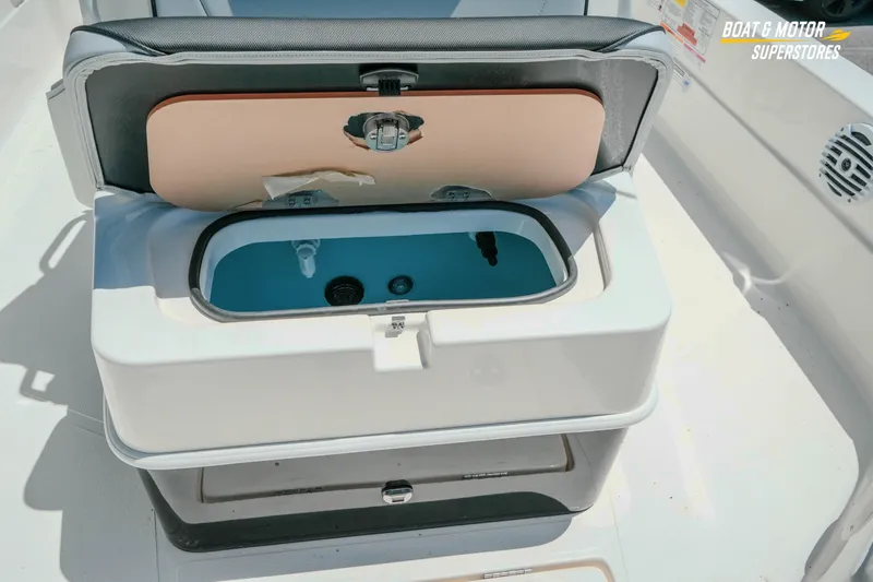Slide: The Image of 2026 Skeeter SX221 boat livewell with open lid, showcasing interior features. - 23