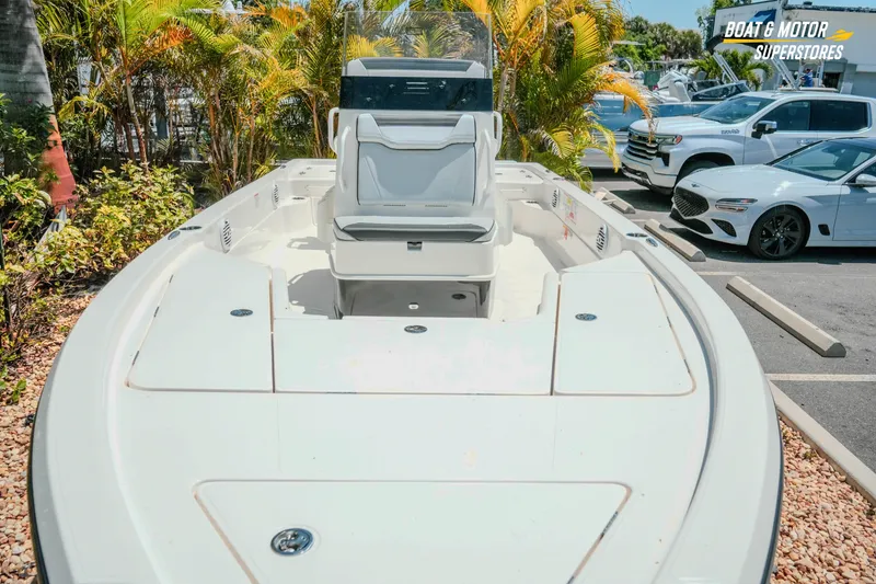 Slide: The Image of 2026 Skeeter SX221 boat displayed at dealership, surrounded by tropical plants and parked cars. - 3