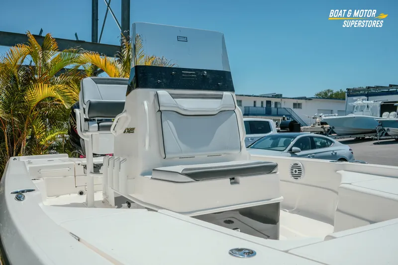 Slide: The Image of 2026 Skeeter SX221 boat interior with seating, parked outdoors at a dealership. - 5