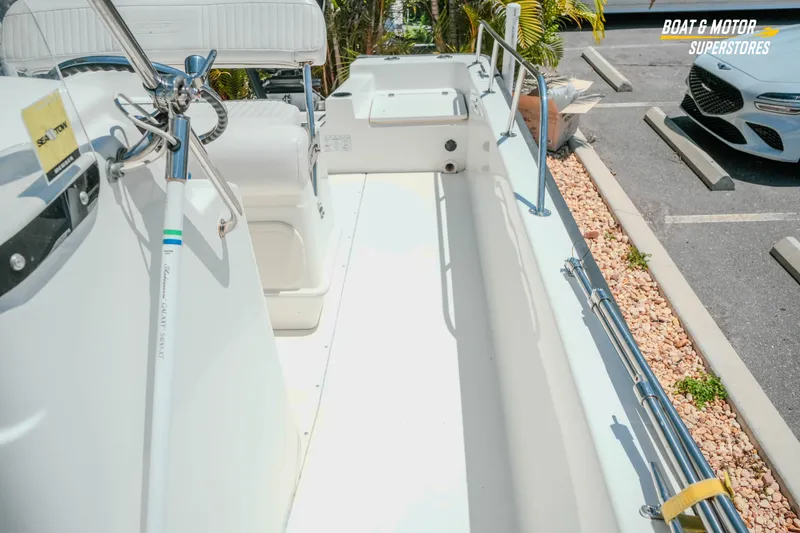 Slide: The Image of 2016 Boston Whaler 210 Montauk boat interior, showcasing seating and steering wheel in a parking lot. - 24