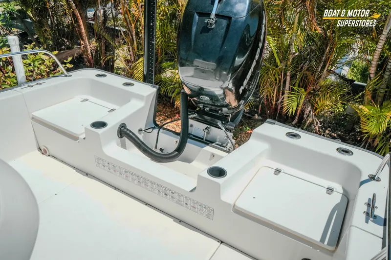 Slide: The Image of 2016 Boston Whaler 210 Montauk boat interior with motor, surrounded by lush greenery. - 26