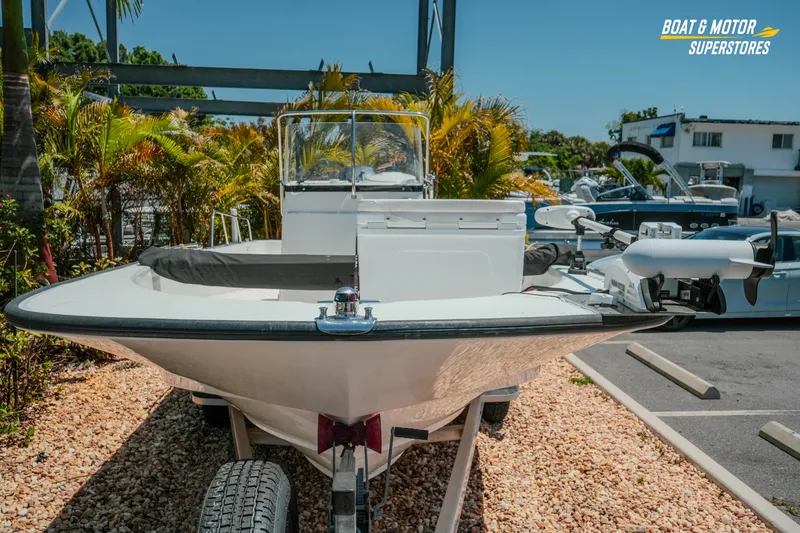 Slide: The Image of 2016 Boston Whaler 210 Montauk boat on trailer at dealership, surrounded by tropical plants. - 4