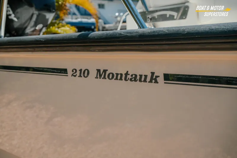 Slide: The Image of 2016 Boston Whaler 210 Montauk boat side view with logo and branding. - 6