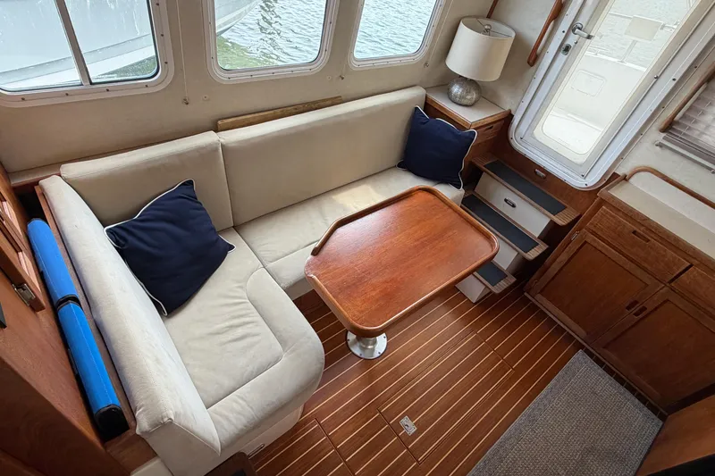 Slide: The Image of Cozy interior of 2007 Nordic Tug 32 with beige seating and wooden table. - 12