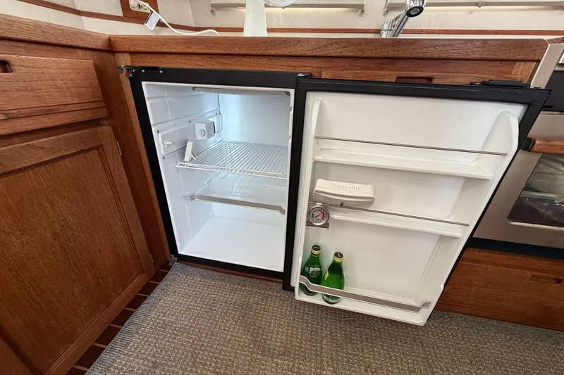 Slide: The Image of Open refrigerator in 2007 Nordic Tug 32 boat galley with wooden cabinetry. - 15