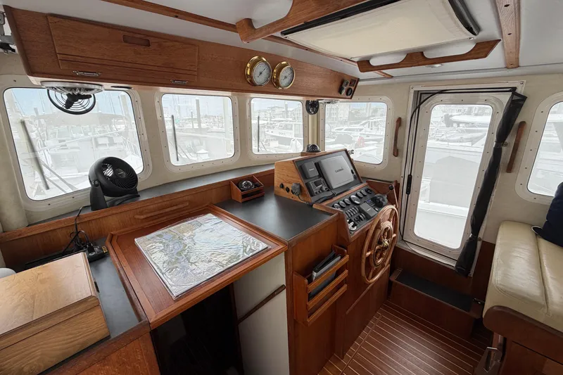 Slide: The Image of Pilothouse of a 2007 Nordic Tug 32 with wooden helm and navigation equipment. - 6