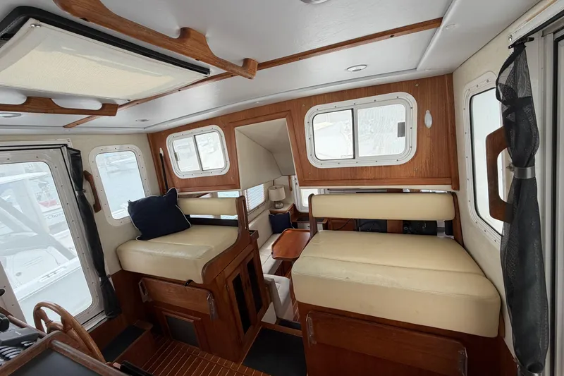 Slide: The Image of Interior of a 2007 Nordic Tug 32, featuring cozy seating and wooden accents. - 7