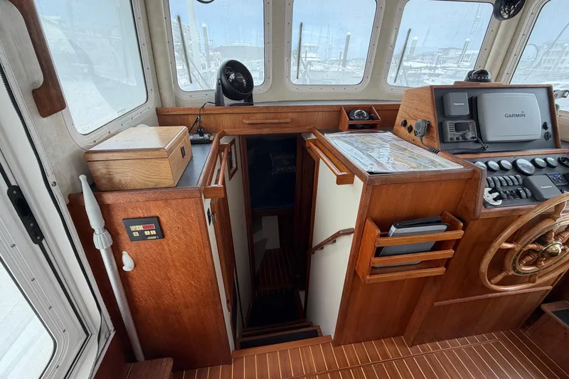 Slide: The Image of Pilothouse interior of 2007 Nordic Tug 32 with navigation equipment and wooden helm. - 9