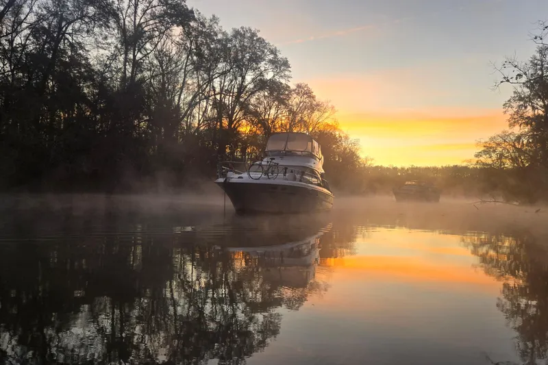 The Image of 2001 Sea Ray 400 Sedan Bridge yacht on clear turquoise water under blue sky. - 0