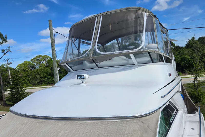 Slide: The Image of 2001 Sea Ray 400 Sedan Bridge yacht on misty lake at sunrise. - 24