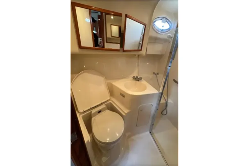 Slide: The Image of Bathroom interior of 2001 Sea Ray 400 Sedan Bridge yacht, featuring toilet, sink, and shower. - 40