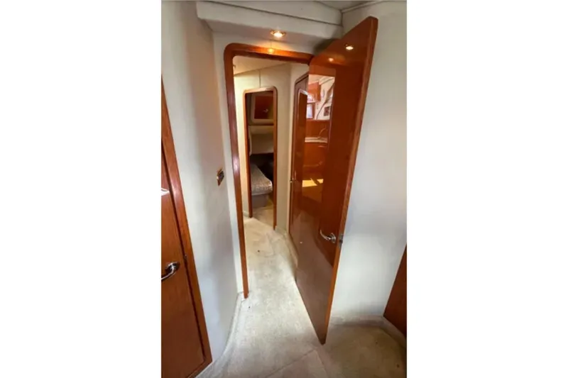 Slide: The Image of Interior hallway of 2001 Sea Ray 400 Sedan Bridge yacht with open wooden doors. - 41