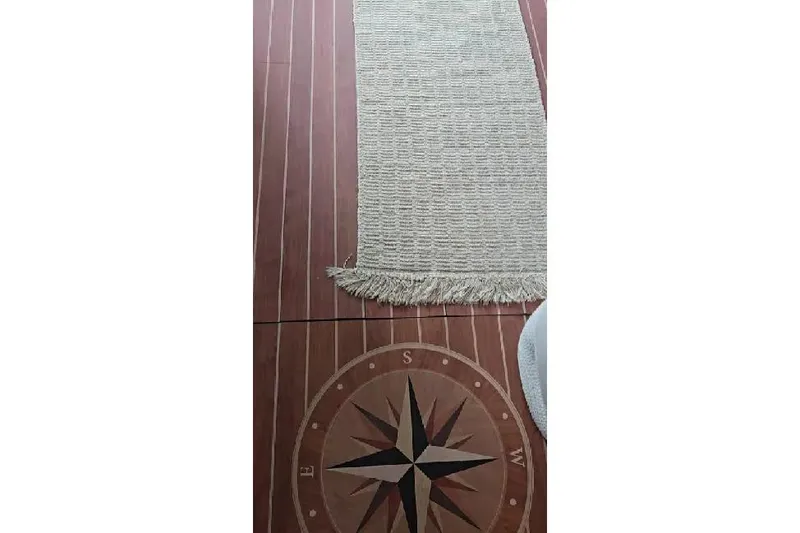 Slide: The Image of Nautical-themed floor with compass design and beige rug on Sea Ray 400 Sedan Bridge. - 42