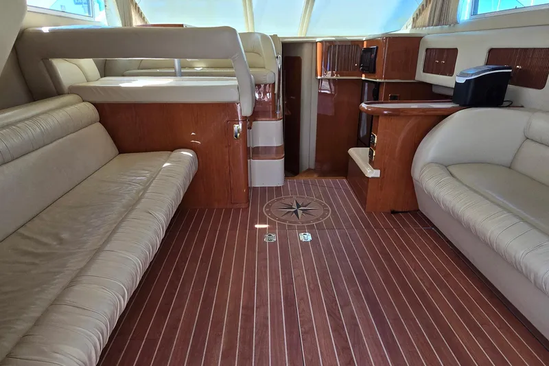 Slide: The Image of Captain's chair on 2001 Sea Ray 400 Sedan Bridge yacht, featuring white leather upholstery. - 9
