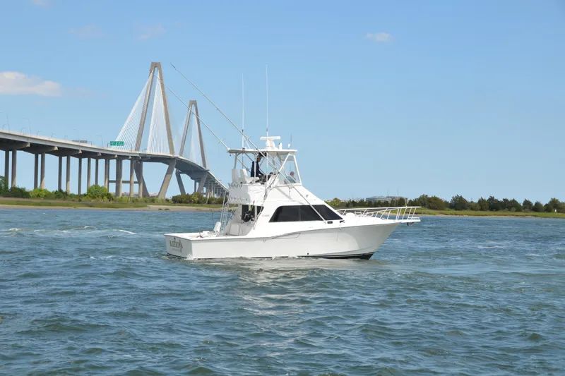 The Image of 2001 Cabo 35 Flybridge boat cruising near a large suspension bridge. - 0