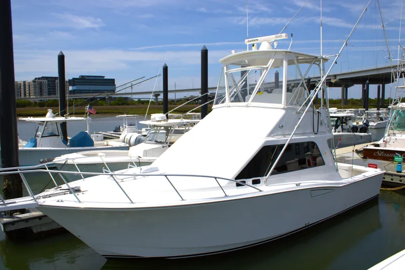 The Image of 2001 Cabo 35 Flybridge boat docked at marina under clear blue sky. - 1