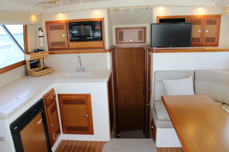 Slide: The Image of Interior of 2001 Cabo 35 Flybridge yacht with kitchenette and seating area. - 12