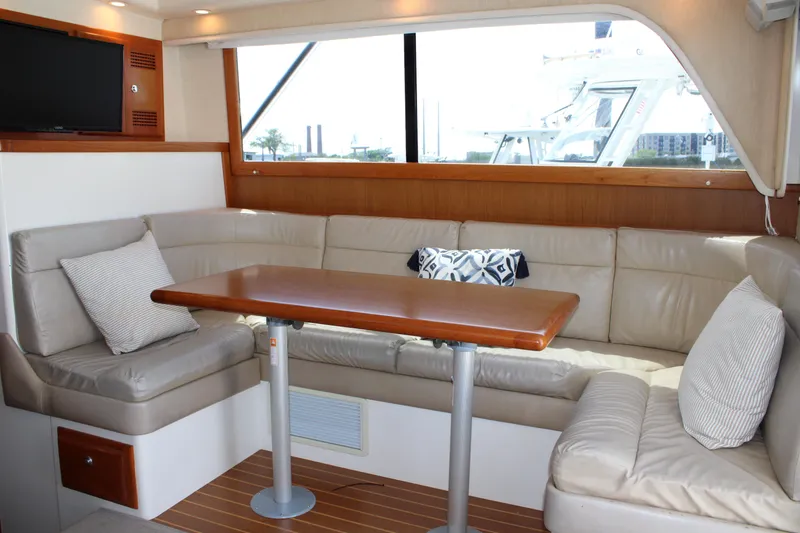 Slide: The Image of Interior of 2001 Cabo 35 Flybridge yacht with beige seating and wooden table. - 13