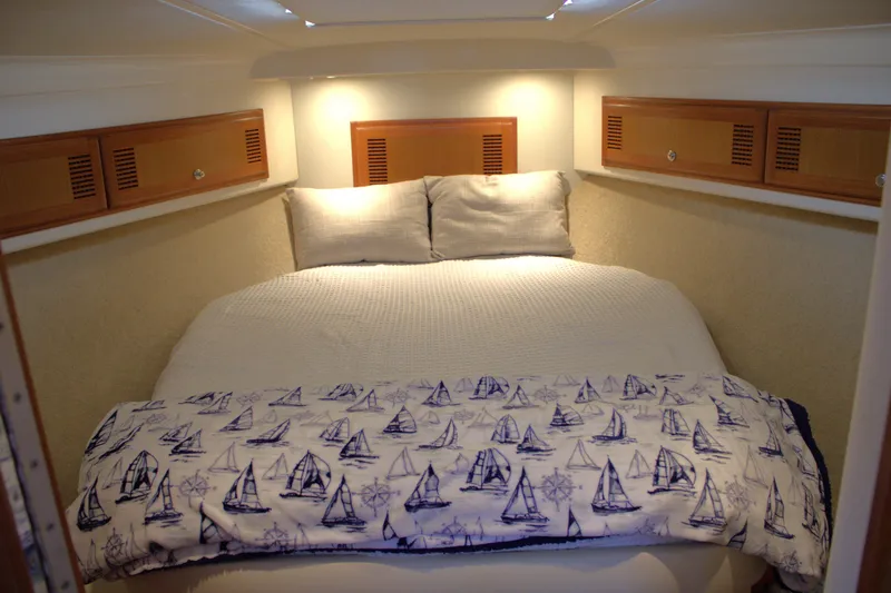 Slide: The Image of Cozy cabin bedroom in 2001 Cabo 35 Flybridge with nautical-themed bedding. - 15