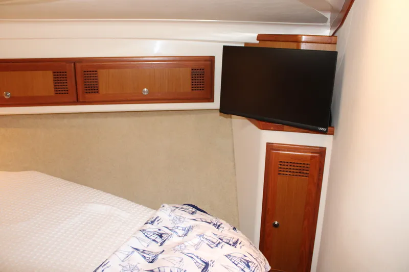 Slide: The Image of Interior cabin of 2001 Cabo 35 Flybridge with TV and wooden storage cabinets. - 16