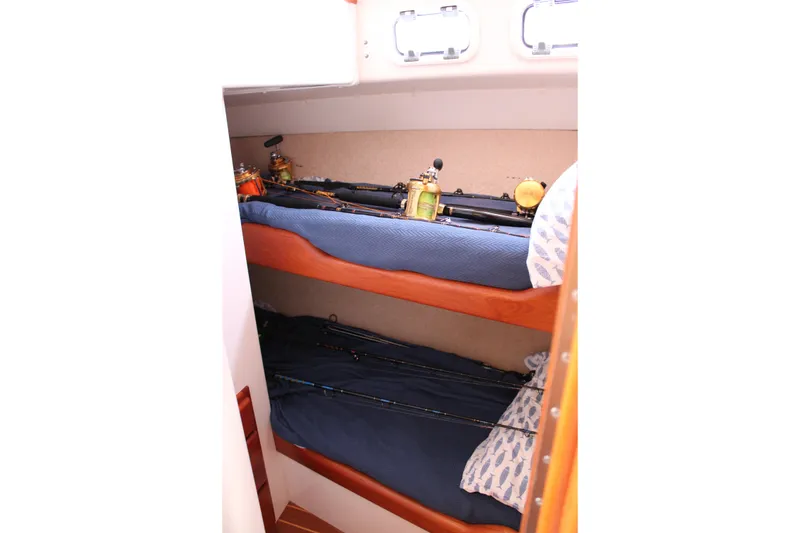 Slide: The Image of Bunk beds with fishing rods on a 2001 Cabo 35 Flybridge boat interior. - 18