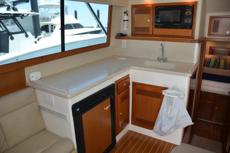 Slide: The Image of Interior of 2001 Cabo 35 Flybridge yacht with kitchenette and seating area. - 24