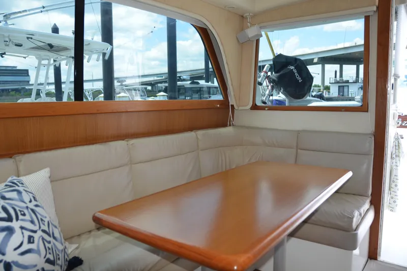 Slide: The Image of Interior of 2001 Cabo 35 Flybridge with cushioned seating and wooden table. - 25