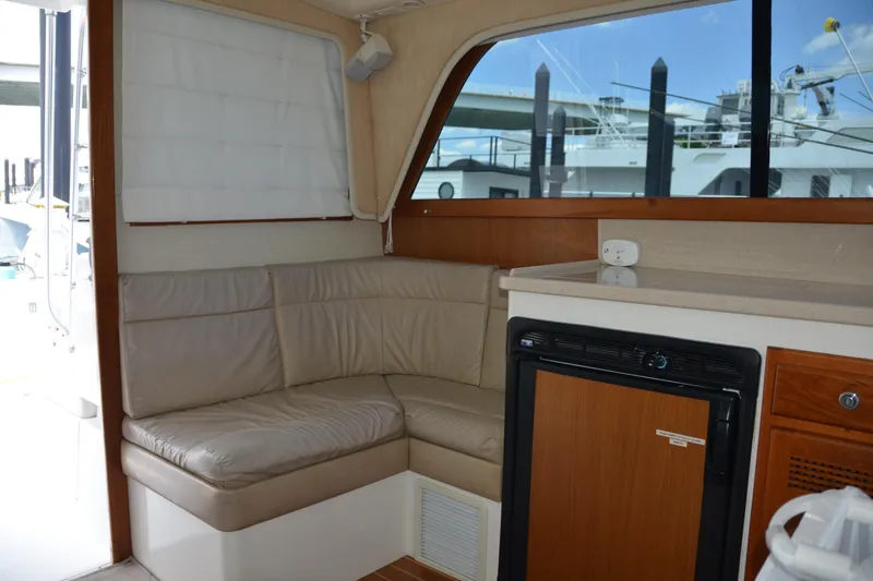 Slide: The Image of Interior of 2001 Cabo 35 Flybridge with beige seating and compact kitchenette. - 27