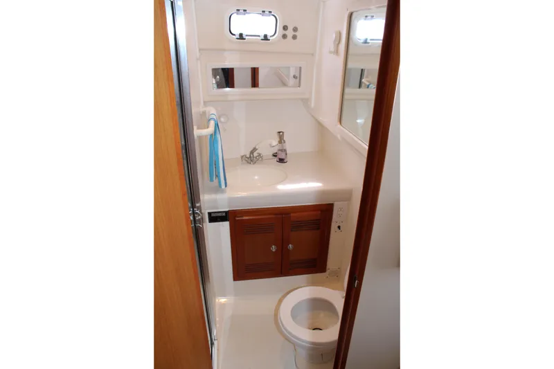 Slide: The Image of Compact bathroom in 2001 Cabo 35 Flybridge yacht with sink, mirror, and toilet. - 35